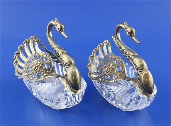 A pair of 1990s repousse silver mounted cut glass sweetmeat dishes modelled as swans, height 6in.